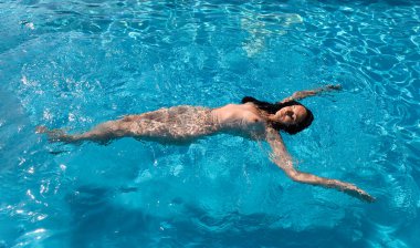 Açık havada çıplak bir kadın. Yüzme havuzunda genç ve güzel bir kadın..