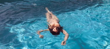 Açık havada çıplak bir kadın. Yüzme havuzunda genç ve güzel bir kadın..