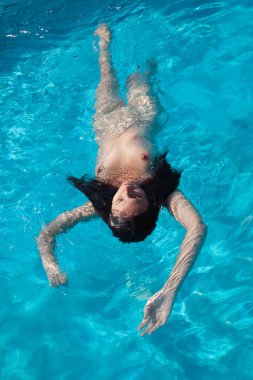 Açık havada çıplak bir kadın. Yüzme havuzunda genç ve güzel bir kadın..