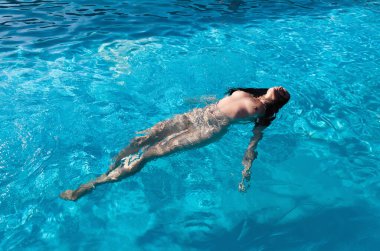 Açık havada çıplak bir kadın. Yüzme havuzunda genç ve güzel bir kadın..