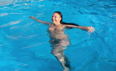 Atom bombası atılmış bir kadın. Yüzme havuzunda güzel çıplak bir kadın. Genç çıplak kadın açık havuzda yüzüyor.