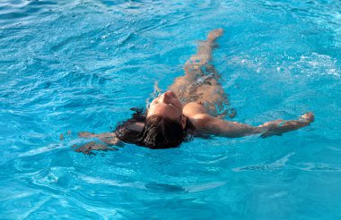 Atom bombası atılmış bir kadın. Yüzme havuzunda güzel çıplak bir kadın. Genç çıplak kadın açık havuzda yüzüyor.