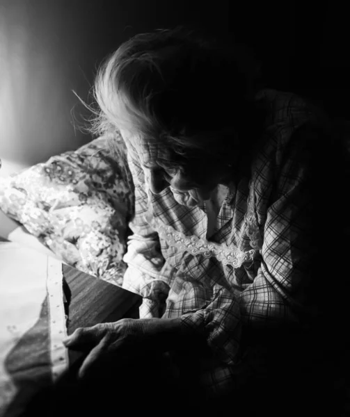 Vieille Femme Assise Sur Canapé Dans Pièce Sombre Près Table — Photo