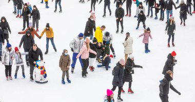 KYIV, UKRAINE - Ocak 03, 2021: buz pateni insanları. İnsanlar buz pateni sahasında eğleniyor. Kyiv 'de yeni yıl tatili.