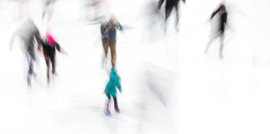 Hareket, buz pateni pistinde kayan insanların soyut görüntüsünü bulanıklaştırdı. Buz pateni yapan insanlar..