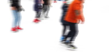 Hareket, buz pateni pistinde kayan insanların soyut görüntüsünü bulanıklaştırdı. Buz pateni yapan insanlar..