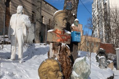 KYIV, UKRAINE - 31 Ocak 2021: Kiev 'deki bir apartmanın karlı avlusunda toplanan totaliter dönemin anıtları. Lenin 'in heykelleri ve devrimin diğer liderleri.