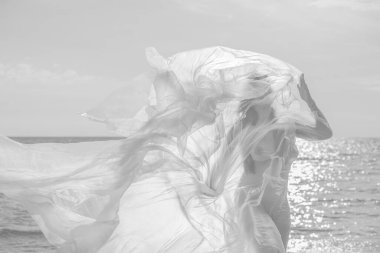 Güzel çıplak kadın vücudu plastiğin altında, arka planda. Rüzgarlı bir günde deniz kenarında polietilen bir filmin arkasındaki seksi kız. Güzel sanatlar fotoğrafı..