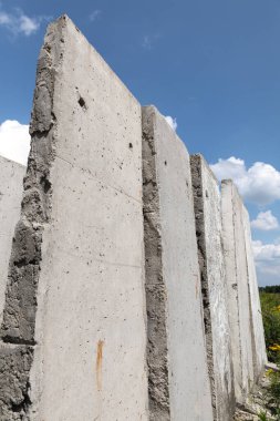 Yazın güneşli bir günde tarlada duran beton levhalar. Bitmemiş eski bina