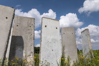 Yazın güneşli bir günde tarlada duran beton levhalar. Bitmemiş eski bina