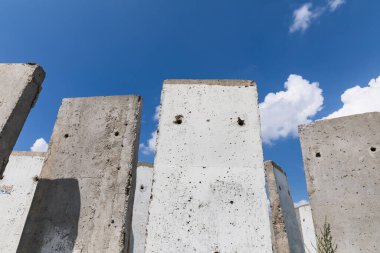 Yazın güneşli bir günde tarlada duran beton levhalar. Bitmemiş eski bina