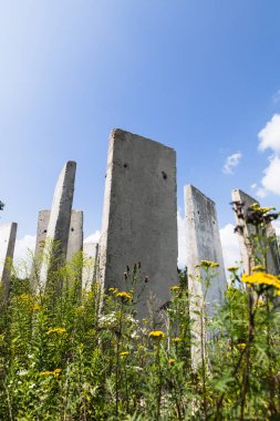 Yazın güneşli bir günde tarlada duran beton levhalar. Bitmemiş eski bina