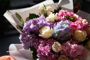 Güneş ışığının altında bir buket gül ve ortanca buketi. Çiçek arkaplanı