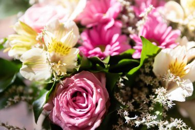 Bir buket gül ve güneş ışığında diğer yaz çiçekleri. Çiçek arkaplanı