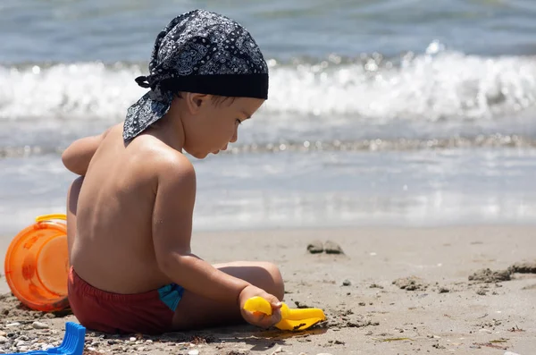 Ένα Μικρό Αγόρι Κάθεται Για Πρώτη Φορά Στην Παραλία Απολαμβάνοντας — Φωτογραφία Αρχείου