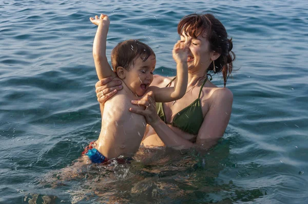 幸せな家族と健康的なライフスタイル 若いお母さんは子供に海で泳ぐことを教える — ストック写真