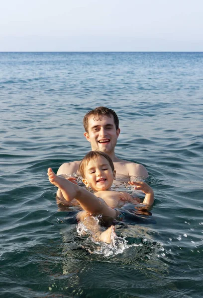 幸せな家族と健康的なライフスタイル 幼い父親が子供に海で泳ぐことを教える — ストック写真
