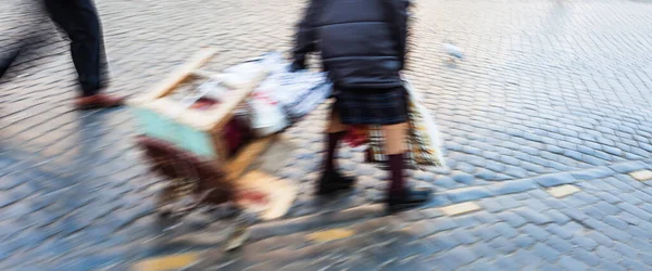 背景模糊的人在街上的抽象形象 故意的动作模糊了 一位老妇人用她的东西拖着一辆购物车 — 图库照片