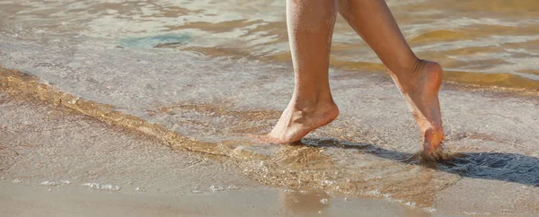 若い女性は砂浜を歩いている 海辺の砂の中の女性の足 — ストック写真