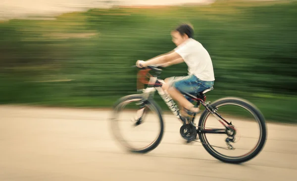 Pojke cyklist i trafiken på stadens vägbanan — Stockfoto
