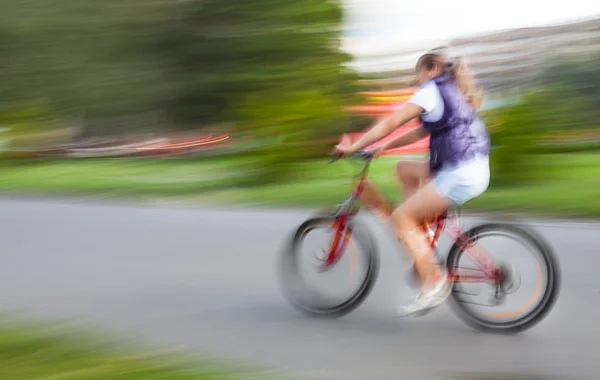 Flicka cyklist i trafiken på stadens vägbanan — Stockfoto