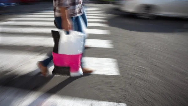 Kvinna med shopping väska korsar gatan — Stockfoto