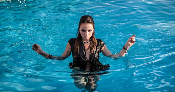 Mujer mojada en vestido negro en una piscina — Foto de Stock