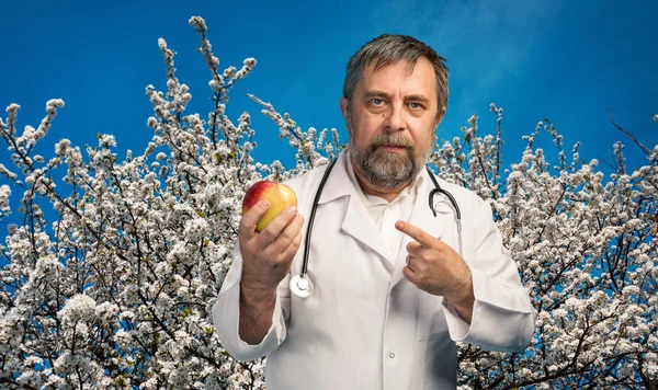 Doctor giving apple for healthy eating — Stock Photo, Image