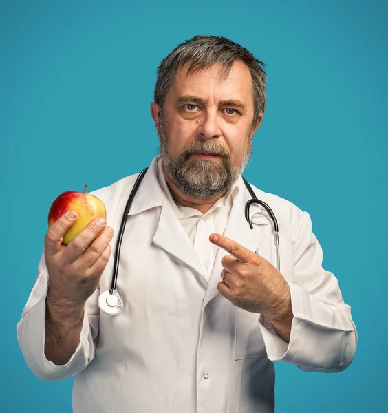 Médico dando manzana para una alimentación saludable — Foto de Stock