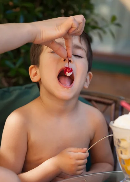 Menino quer comer uma cereja — Fotografia de Stock