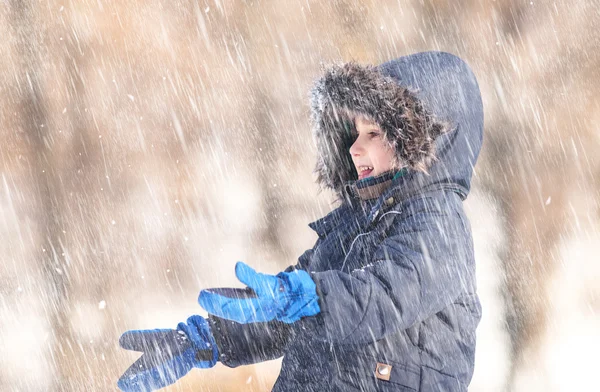 Ładny chłopiec bawi się śnieg — Zdjęcie stockowe