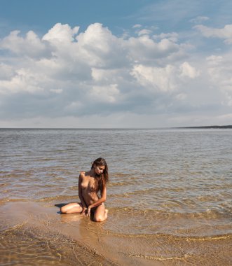 Deniz kenarında güzel genç çıplak kadın