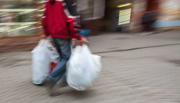 Abstract beeld van een man in sportkleding met winkelen plastic zakken — Stockfoto