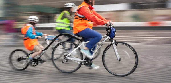 Familia joven con un niño en bicicleta en las calles de una ciudad — Foto de Stock