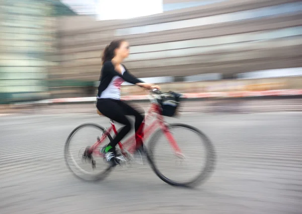 Chica ciclista en el tráfico en la carretera de la ciudad — Foto de Stock