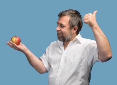Kırmızı elma ile Beyaz tişörtlü orta yaşlı adam