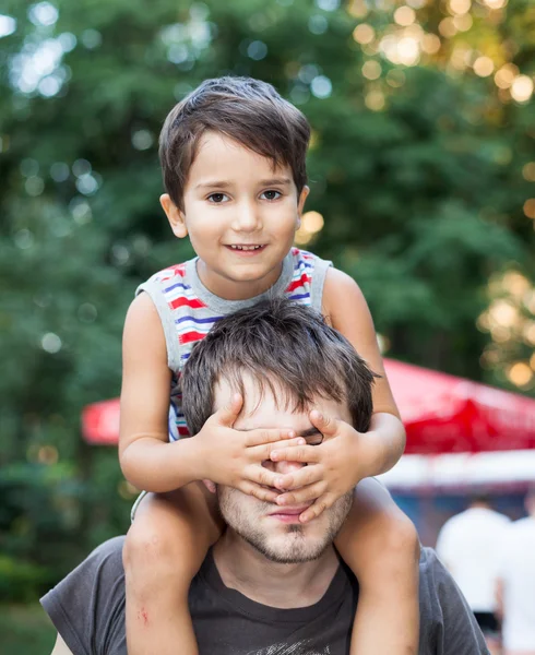 Bambino seduto sul collo di suo padre — Foto Stock