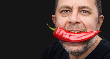 ihtiyar bir adamın ağzında kırmızı biber ile
