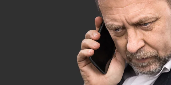 Homem de negócios fala em um telefone celular — Fotografia de Stock