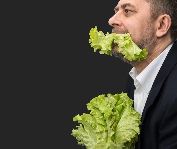 Man holding and eating lettuce — Stock Photo, Image