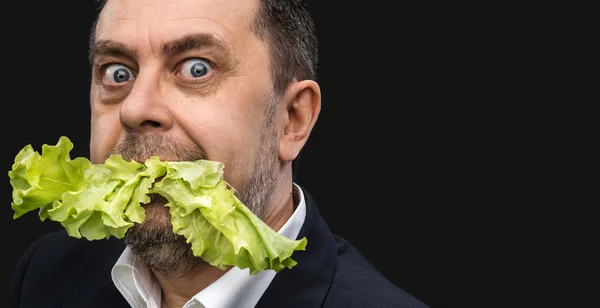 Man holding and eating lettuce — Stock Photo, Image
