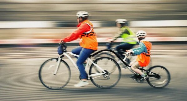 Giovane famiglia con un bambino andare in bicicletta su una strada della città — Foto Stock