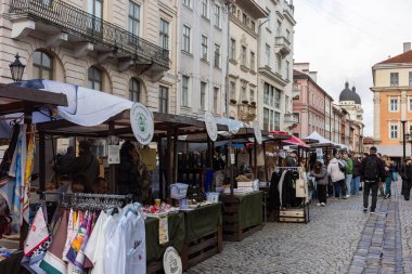 Lviv, Ukrayna - 12 Ekim 2025: Esnaf mallarını Lviv 'deki Pazar Meydanı' nda renkli tezgahları ve dostça etkileşimleri olan ziyaretçileri cezbeden canlı bir fuarda sergiliyor..
