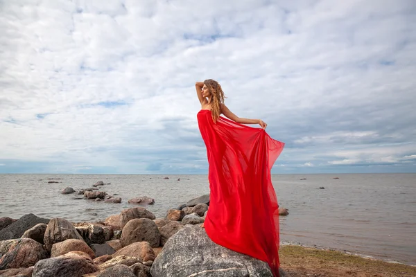 Donna con tessuto rosso sulla spiaggia di mare — Foto Stock