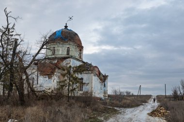 Harkiv bölgesinde askeri operasyonlar sırasında yıkılan bir kilise görülüyor. Hasarlı kubbe mavi muşambayla kaplanırken yolda tek bir kişinin yürüdüğü görülüyor..