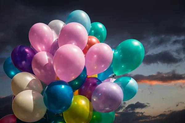 Multi-färgade ballonger mot mulen himmel — Stockfoto