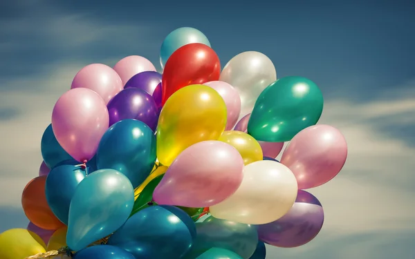 Multi-färgade ballonger på blå himmel bakgrund — Stockfoto