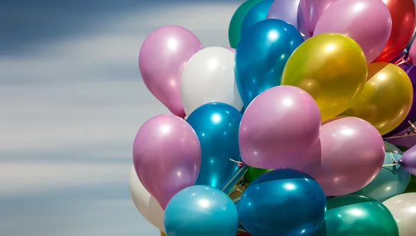 Multi-färgade ballonger på blå himmel bakgrund — Stockfoto