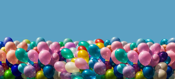 Multi-colored balloons isolated on blue Stock Image