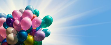 Mavi gökyüzü güneş ışığı ile karşı çok renkli balonlar